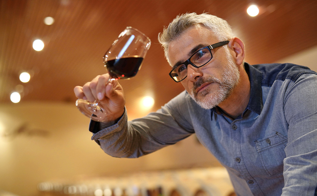 Wine consultant inspecting glass