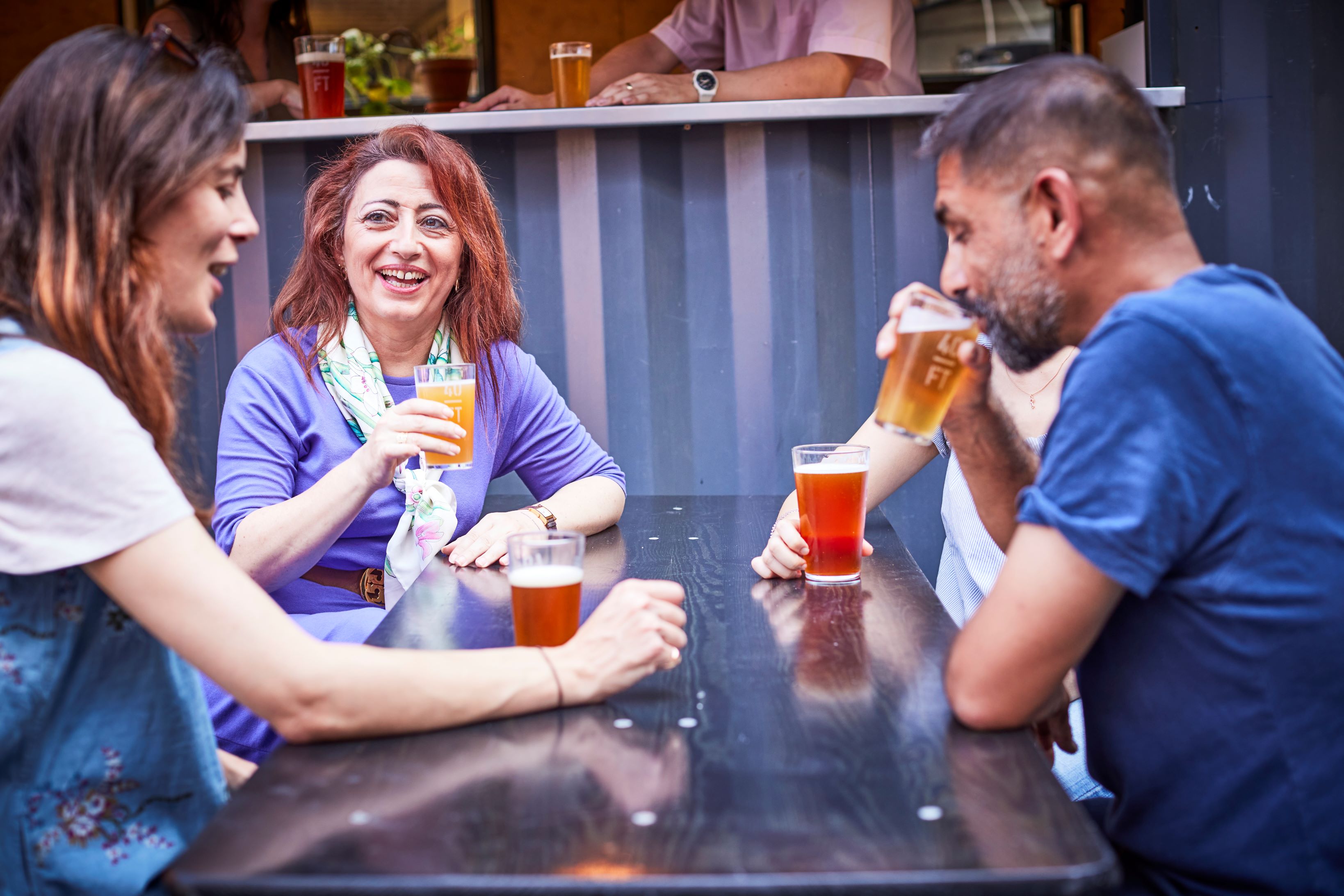 Three people sipping beer
