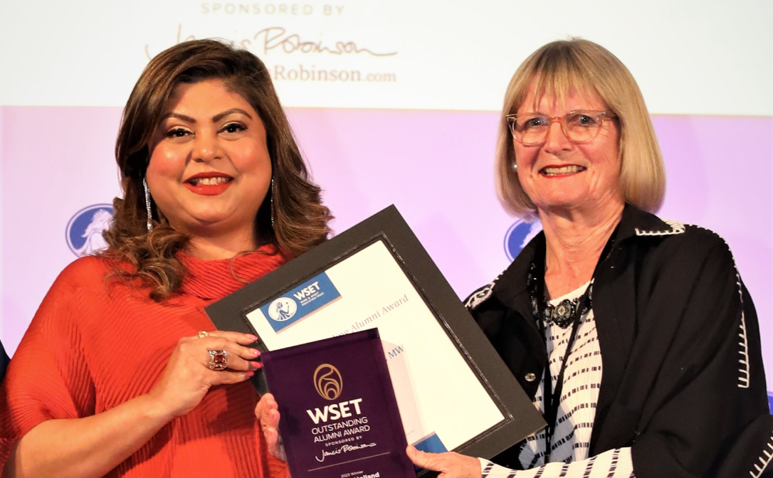 Sonal Holland, holding her certificate, standing next to Jancis Robinson on stage.