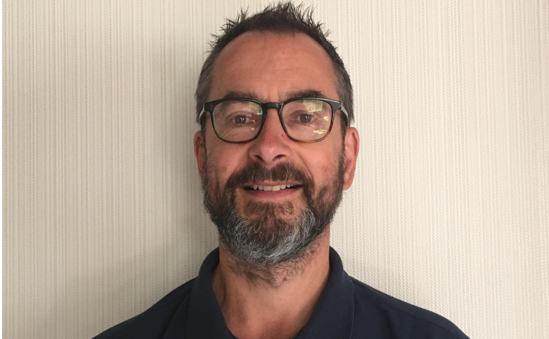 A man wearing glasses, looking directly at the camera