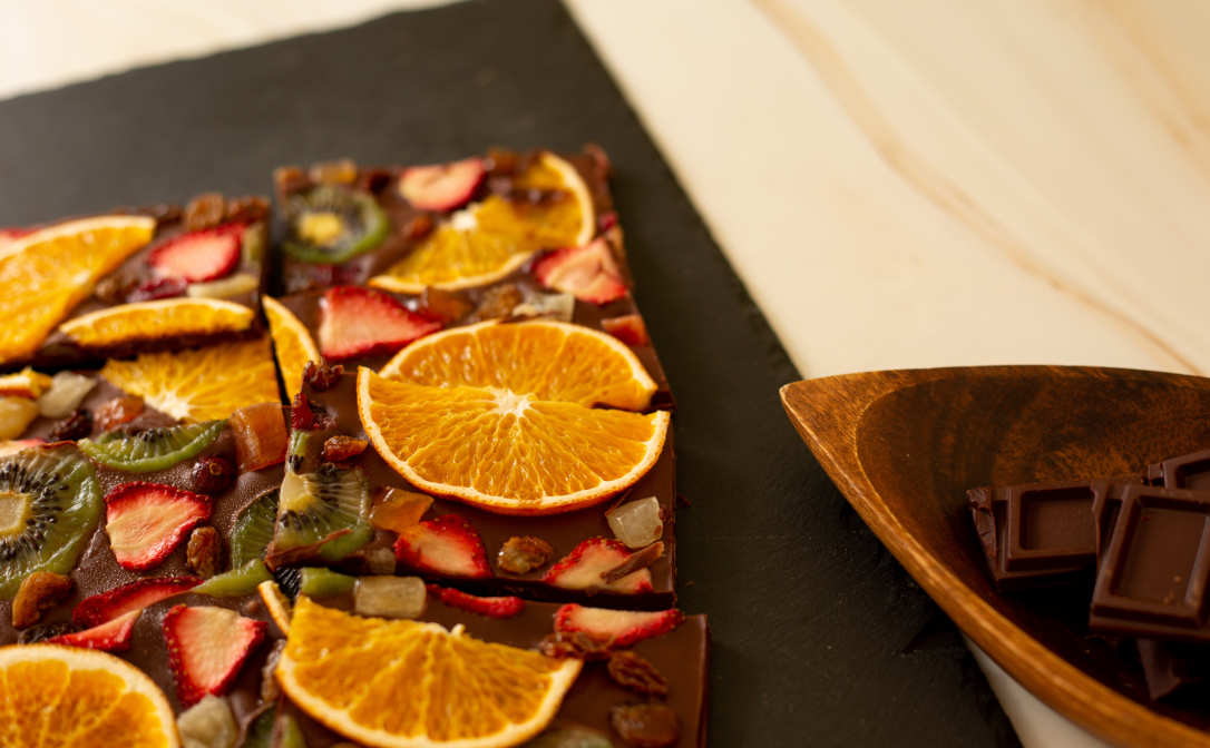 Thin dark chocolate, topped with dried orange slices, strawberry and kiwi